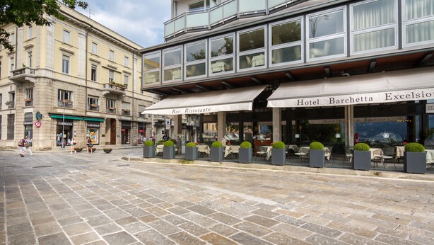 A street with a building featuring a bar and restaurant named "Bar Ristorante" and "Hotel Barchetta Excelsior". - AT THE HOME OF PABLO COMO (Como)