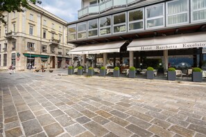 A street with a building featuring a bar and restaurant named "Bar Ristorante" and "Hotel Barchetta Excelsior". - AT THE HOME OF PABLO COMO (Como)