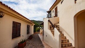 A narrow alleyway with a stone-paved path, a staircase, and a building with a tiled roof and wooden shutters. - FANTASTICO PORTO OTTIOLU GR1 (Budoni)
