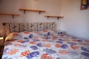 A bedroom with a floral bedspread, wooden headboard, and bedside tables. - FANTASTICO PORTO OTTIOLU GR4 (Budoni)
