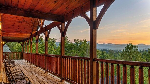 A wooden deck with a railing overlooking a forested landscape. - Free Tickets | 2 Hot Tubs, Arcade, Fireplace, Parking, Easy Access for Buses (Gatlinburg)