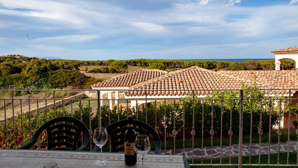 A terrace with a table, two chairs, and a bottle of wine. - FANTASTICO PEDRAMI 1 (Budoni)