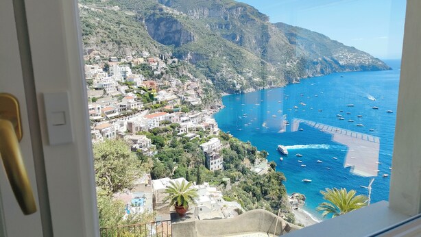 A coastal town with buildings on a hillside, a clear blue sea, and boats. - Villa with a spectacular view,  in a peaceful location, very romantic, (Positano)