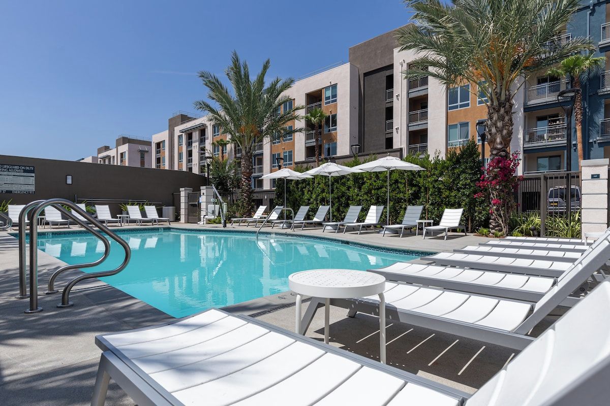 Resort-style pool with lounge chairs and palm trees