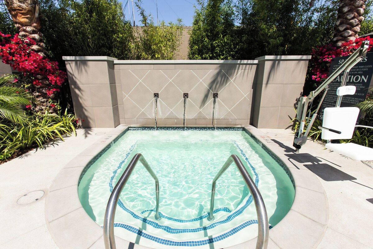Relaxing community hot tub surrounded by palms and flowers