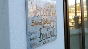 A welcome sign with multiple languages on a building's exterior wall. - Ostello Il Volto (Potenza)