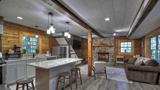 Una cocina moderna con una isla grande, taburetes de bar y una chimenea.