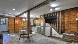 Una cocina amplia con detalles de madera, un televisor integrado y un rincón de descanso acogedor.