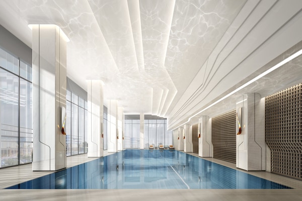 Una piscina techada, una piscina al aire libre, sombrillas