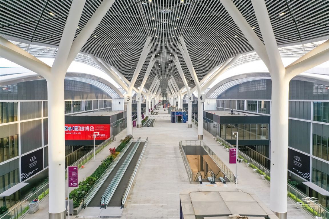 A modern architectural structure with a central atrium, glass railings, and a series of columns.