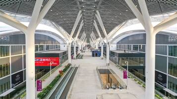 A modern architectural structure with a central atrium, glass railings, and a series of columns.