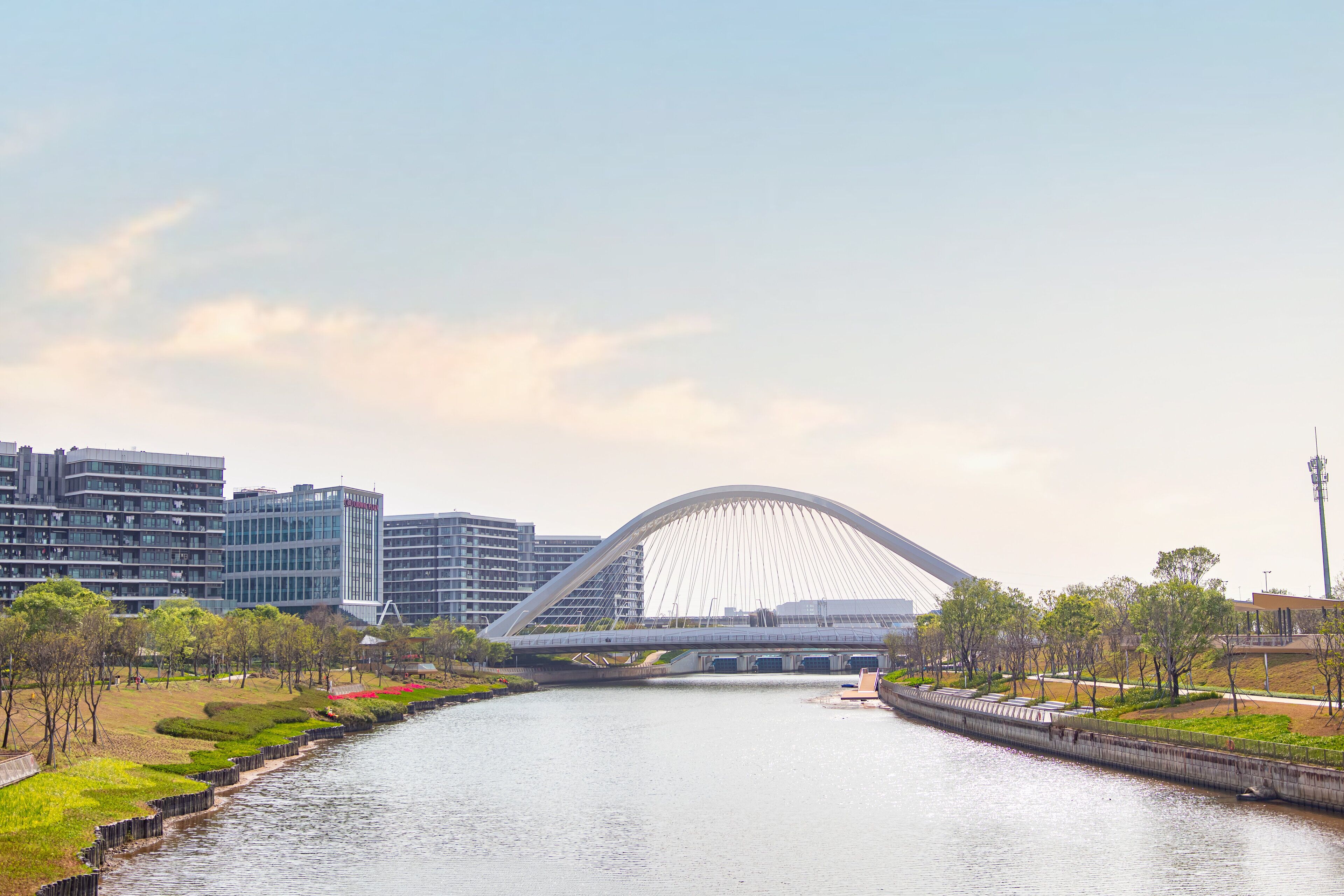 Un pont moderne enjambant une rivière, avec une vue sur la ville en arrière-plan.