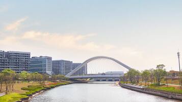 Un pont moderne enjambant une rivière, avec une vue sur la ville en arrière-plan.