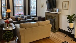 A living room with a fireplace, a television, and a sofa.