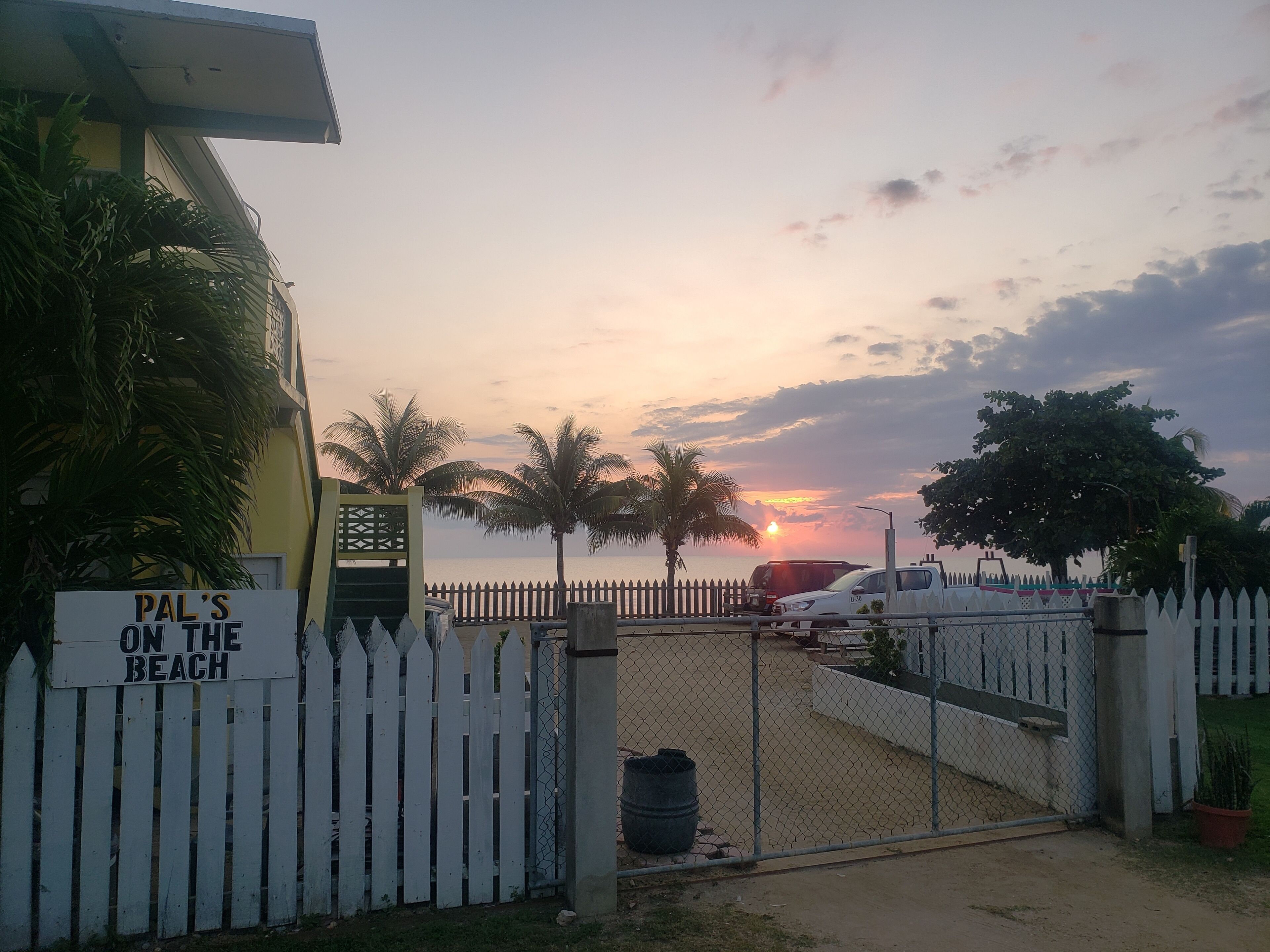 Une entrée fermée par un portail mène à une propriété appelée « Pal’s on the Beach », d’où l’on peut admirer le coucher de soleil sur l’océan.