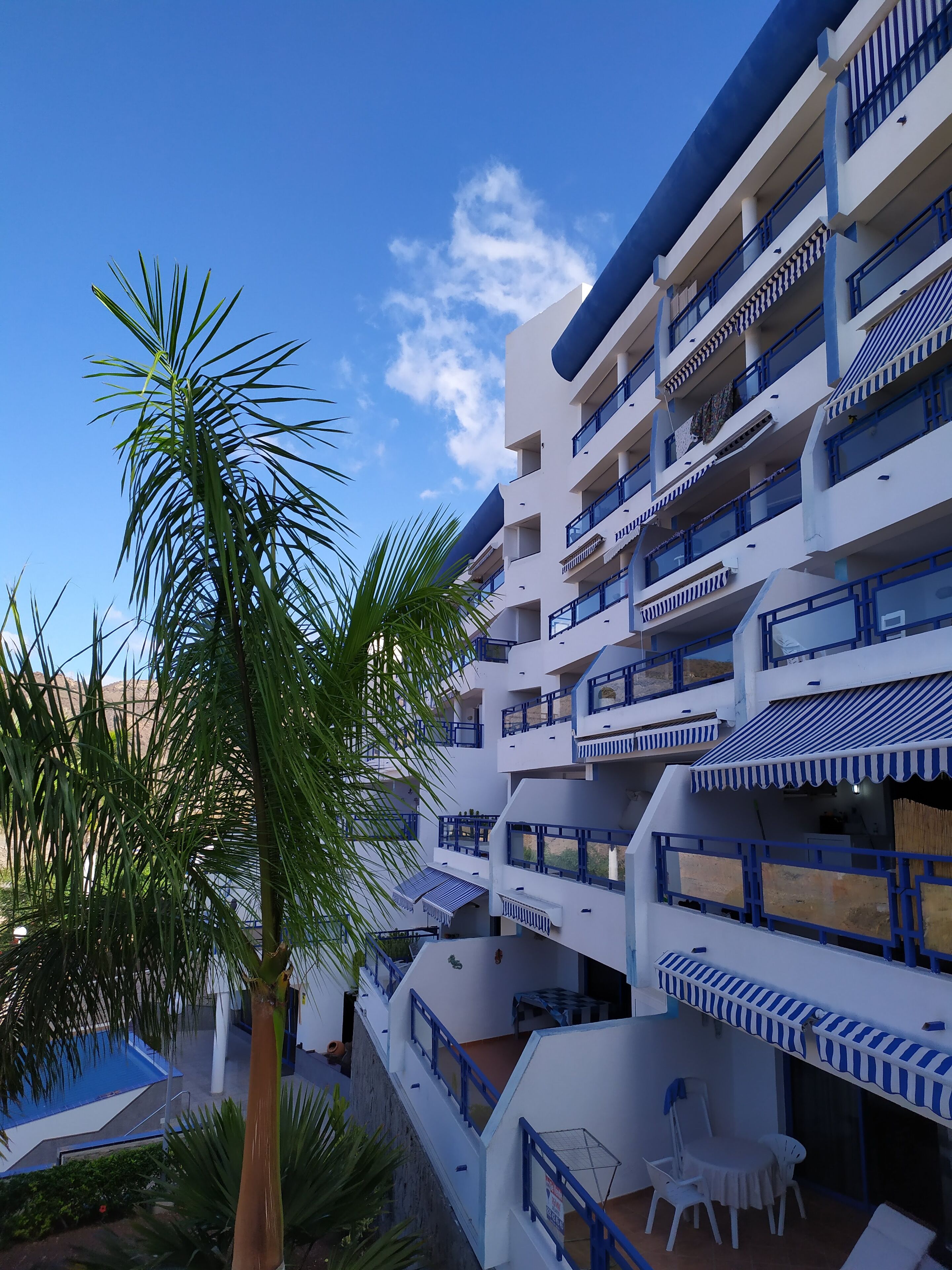 Ein Mehrstöckiges Hotel mit Balkonen, einem Pool und Außenplätzen.
