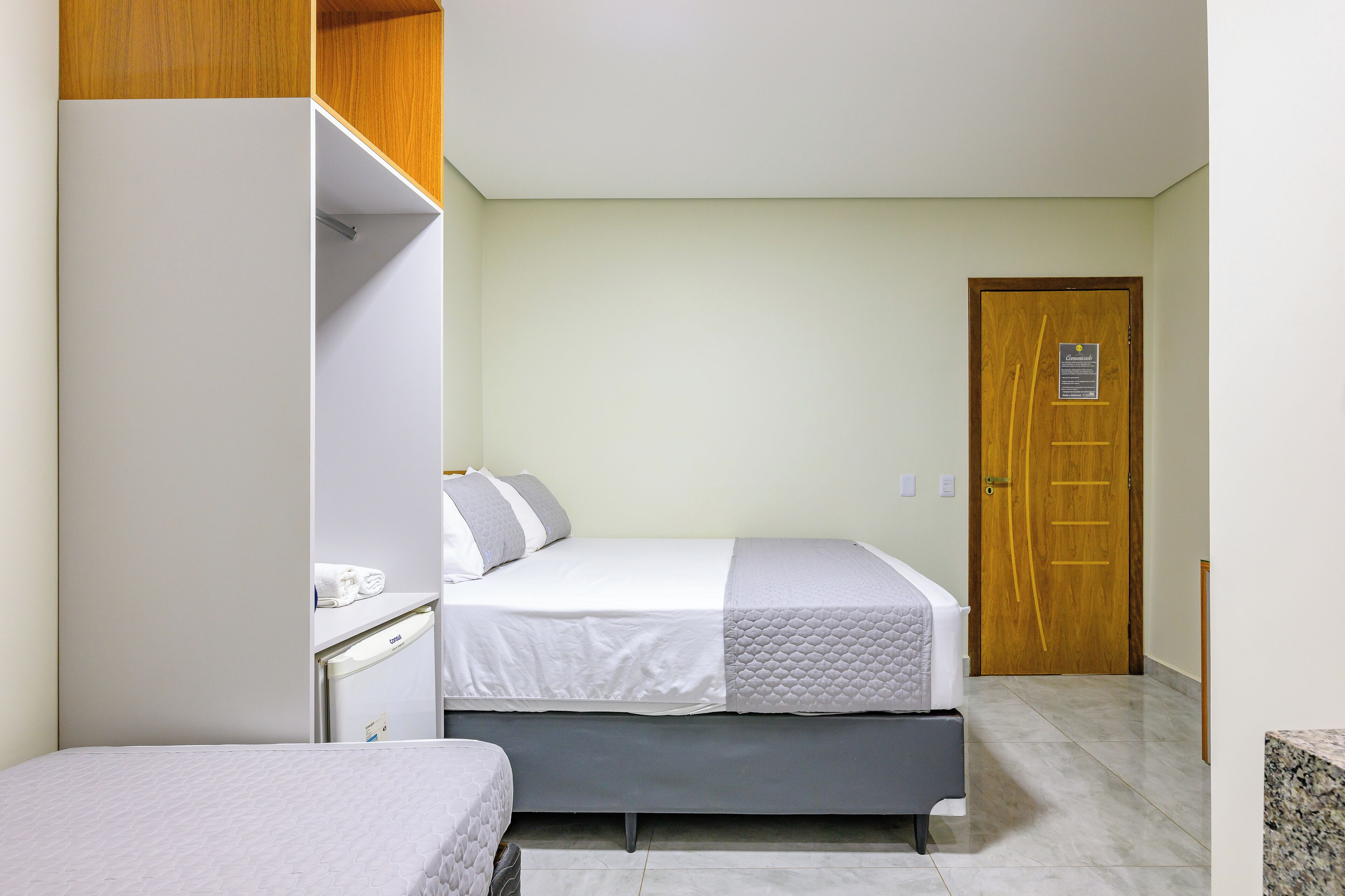 Een slaapkamer met een bed, een kledingkast en een deur.