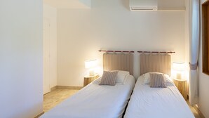 Ein Doppelbett mit gestreifter Bettwäsche und zwei Nachttischlampen.