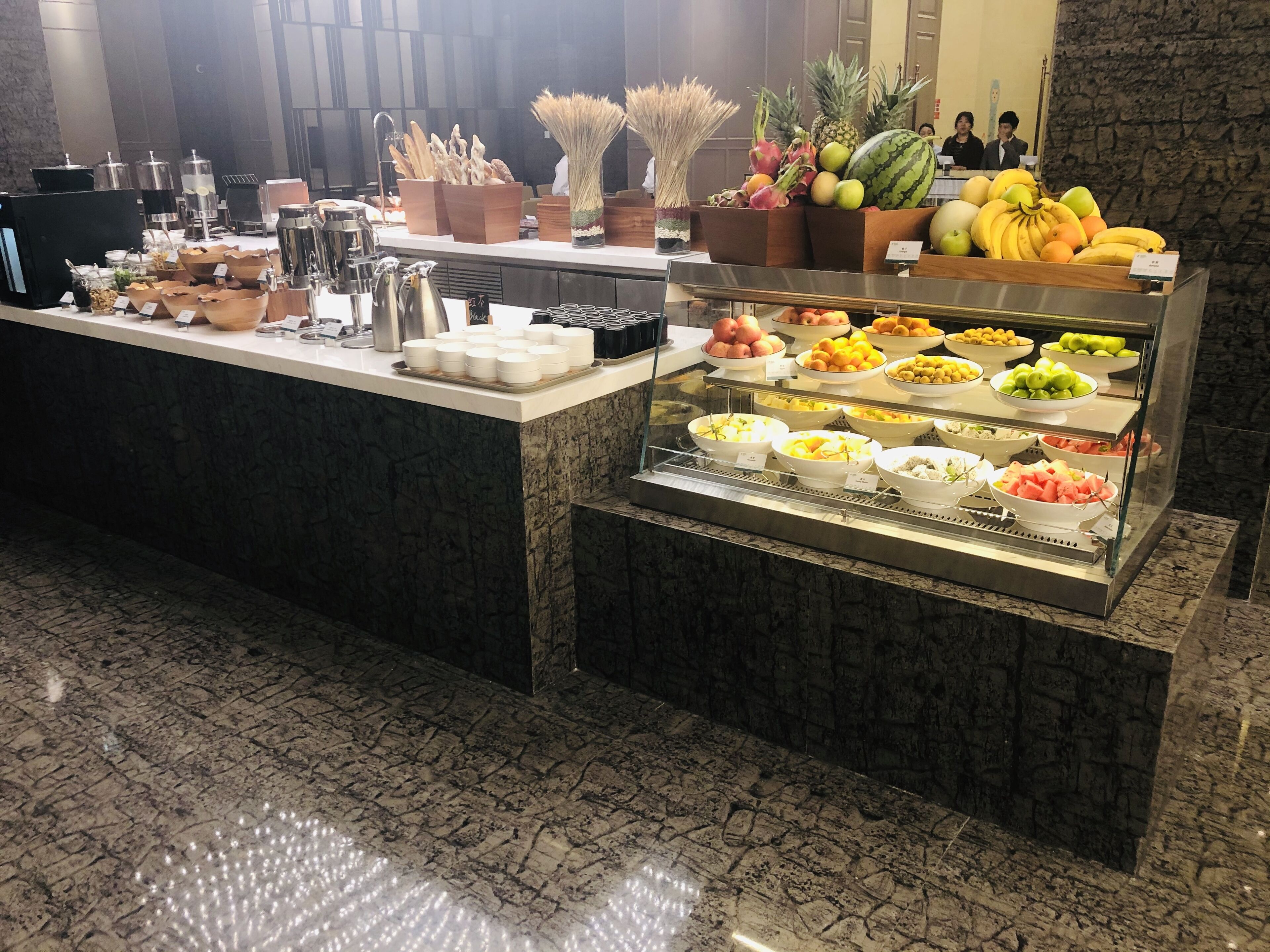Zona de bufé con diversas frutas y bebidas.