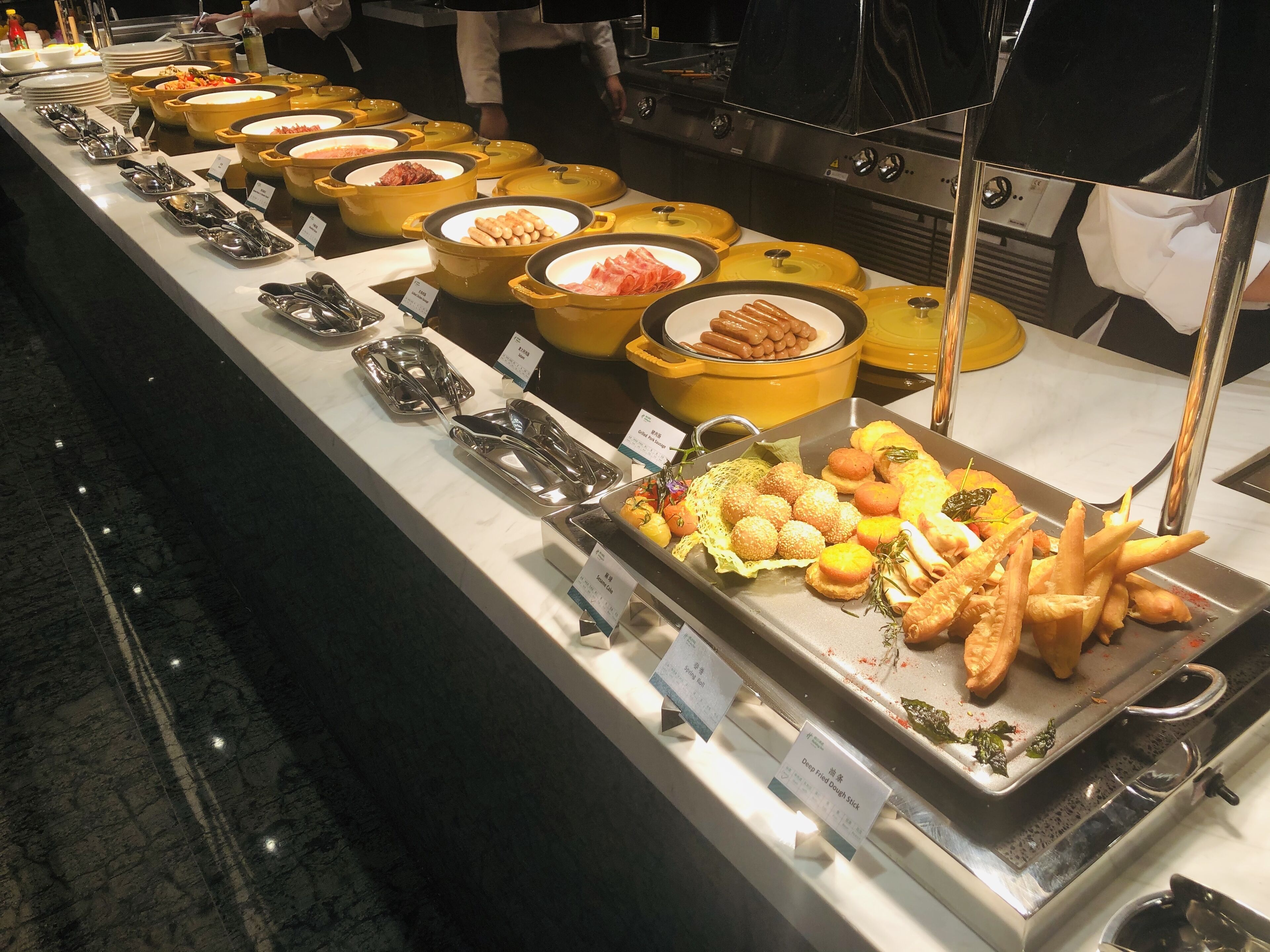 A buffet with various food items and utensils.