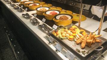 A buffet with various food items and utensils.