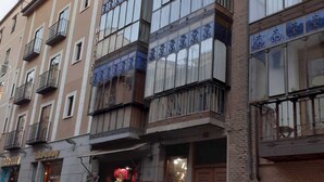 Un immeuble à plusieurs étages, avec un commerce au rez-de-chaussée et des appartements aux étages supérieurs.