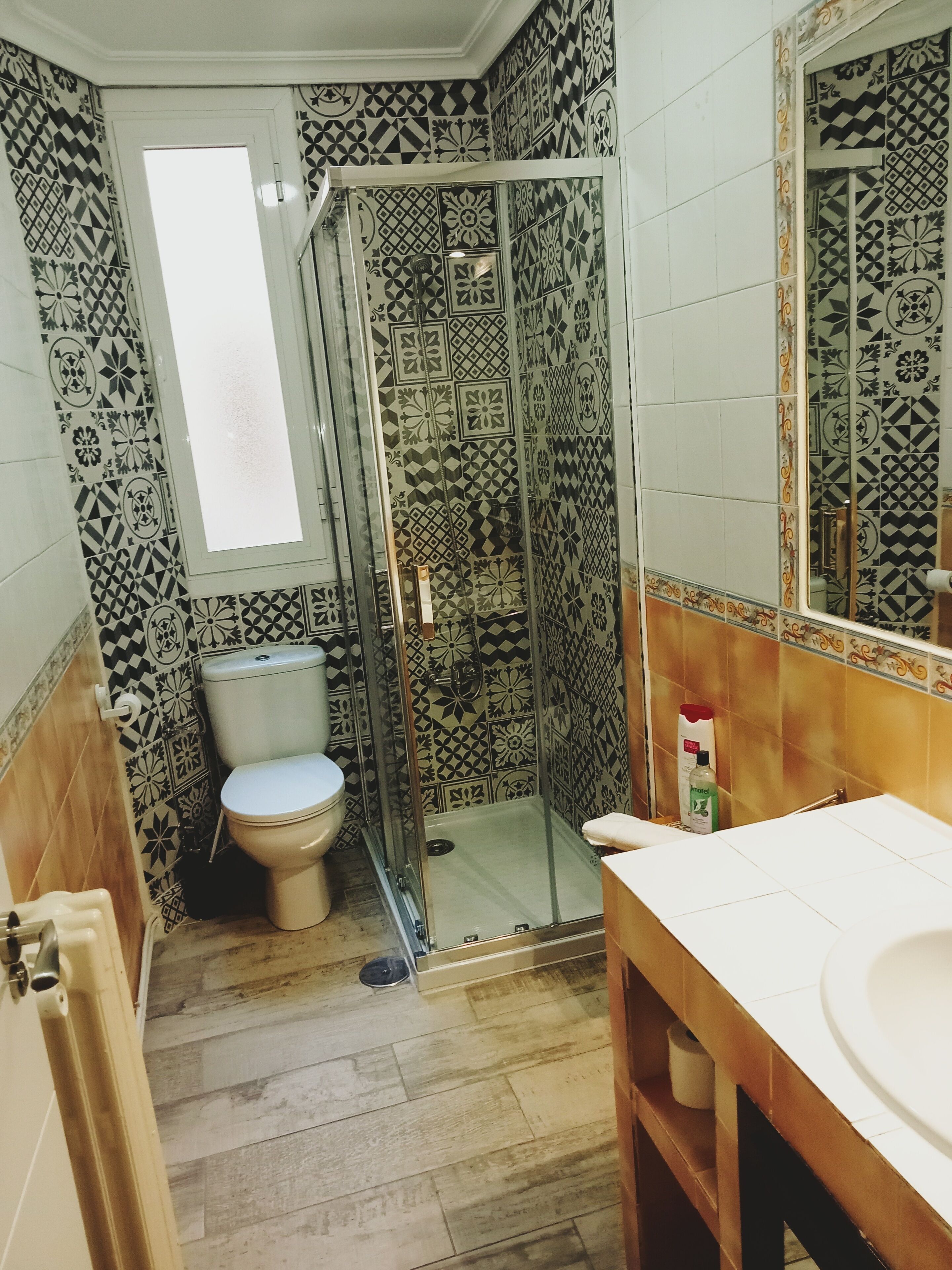 A bathroom with a shower, toilet, and sink.
