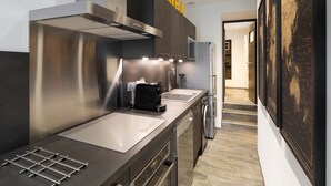 Una cocina moderna con electrodomésticos de acero inoxidable, cafetera y lavavajillas.