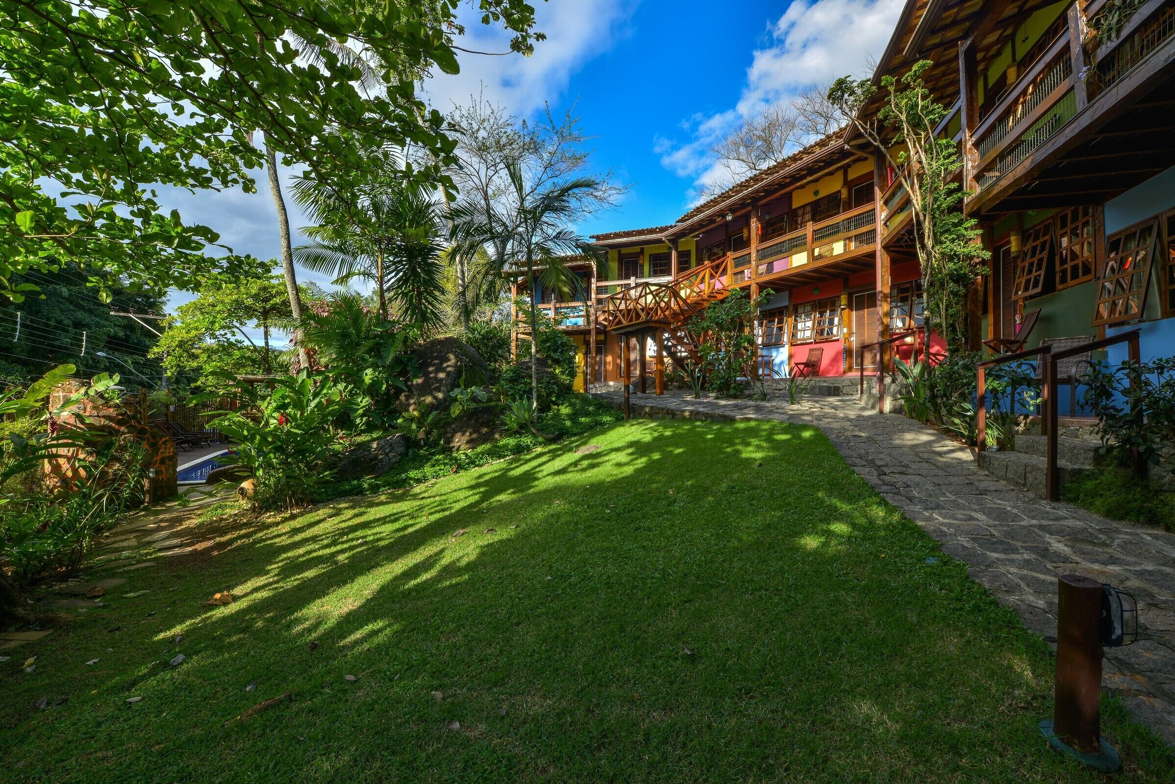 A traditional multi-story building with a central staircase, surrounded by lush greenery and a well-maintained lawn.