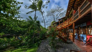 A wooden building with a stone pathway leading to a wooden deck. - Pousada Villa da Prainha (Ilhabela)