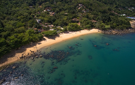 Una playa cerca, arena blanca, sombrillas, toallas de playa