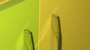 Un mueble amarillo y verde con dos tiradores metálicos.