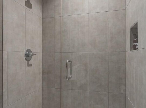 A shower area with tiled walls and a metal handle.