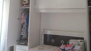 A bedroom with a bed, a wardrobe, and a ceiling light.