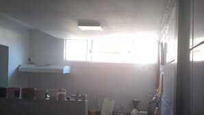 A compact kitchen with basic amenities, including a sink, countertop, and cabinets.