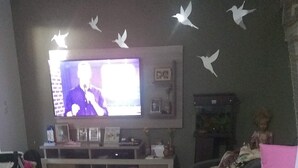 A living room with a television, a sofa, and a small table.