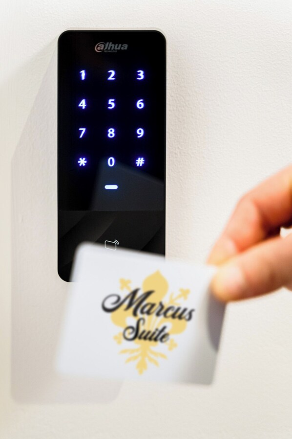 A digital keypad with the brand 'alhua' and a card being inserted into it. - Marcus Suite (Cagliari)