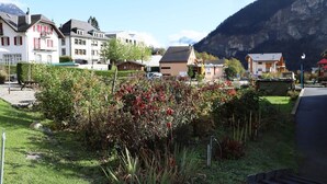 A residential area with houses, a road, and a mountain in the background. - Petit Nid Douillet au Coeur de Salvan (Salvan)