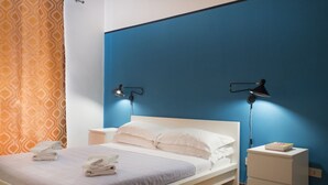 Ein modernes Hotelzimmer mit einem Bett, zwei Nachttischen und einem Beistelltisch mit einem Buch.