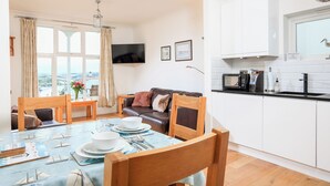 A modern kitchen with white cabinets, a microwave, and a sink. - 1 Lyndhurst (Salcombe)