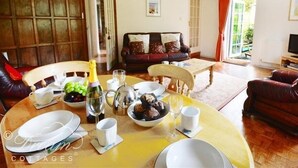 Un saló acollidor amb una taula de menjador preparada per a dinar, un sofà i una televisió.