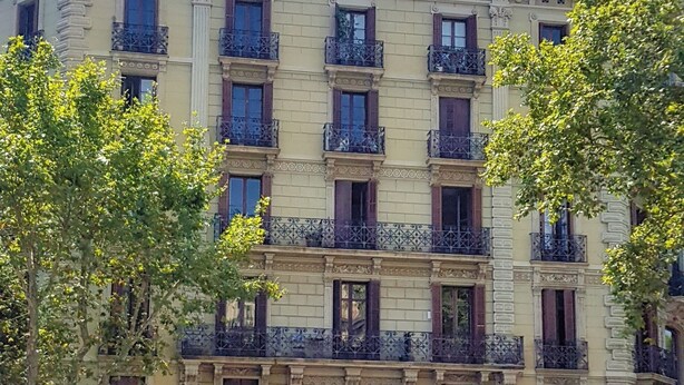 A multi-story building with ornate architectural details, including decorative balconies and a central entrance with a large door. - Homestay CityCenter (Barcelona)