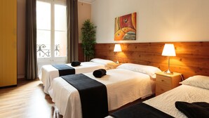 A hotel room with two beds, a wooden headboard, a painting on the wall, and a window with curtains. - Homestay CityCenter (Barcelona)