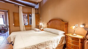 A bedroom with a wooden bed, two bedside tables with lamps, a wooden wardrobe, and a window with curtains. - Monte Verde Ojén by Ruralidays (Málaga)