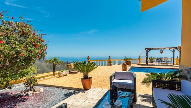 A terrace with a pool, outdoor seating, and a view of the sea. - Villa Calena Almuñécar by Ruralidays (Granada)