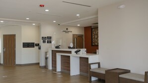 Zona de recepción con un mostrador blanco, piso de madera y señalización de Candlewood Suites.