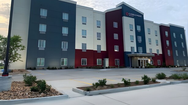 Un hotel de varios pisos con un diseño moderno, que presenta una combinación de colores blanco, rojo y azul en su fachada.