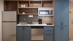 Una cocina moderna con microondas integrado, cafetera y lavavajillas.