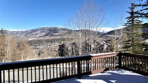 Cubierta nevada con vista a un pueblo y montañas.