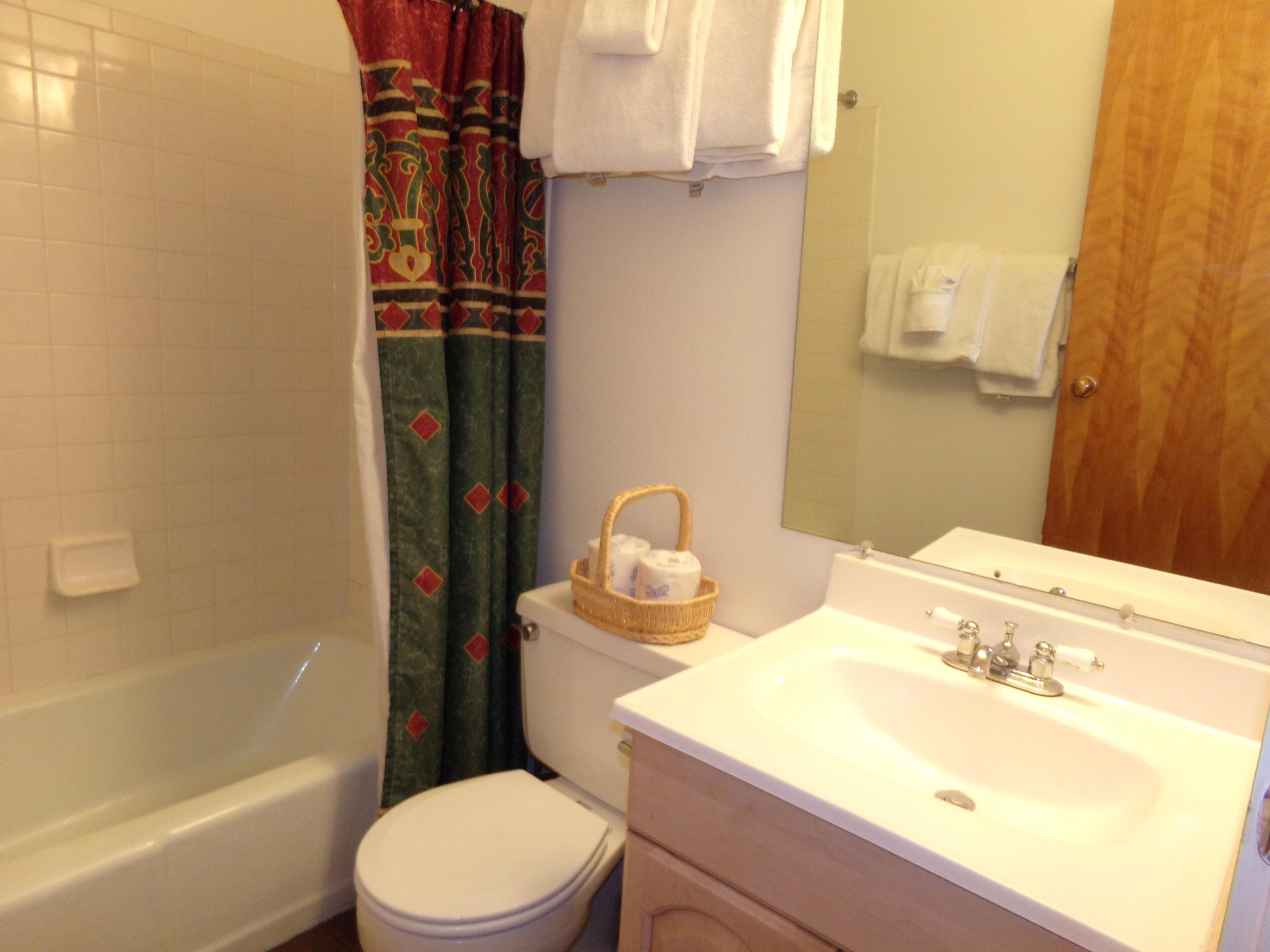 A bathroom with a bathtub, toilet, and sink.
